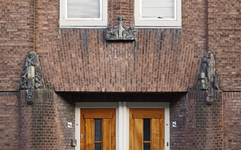 852138 Afbeelding van het beeldhouwwerk, vervaardigd door Hildo Krop, boven de ingang van de huizen Jan van ...